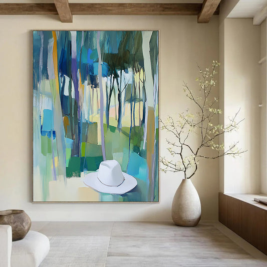 Contemporary abstract painting featuring trees in vibrant blue, green, and yellow hues with a white hat resting on the ground. DLZ0897
