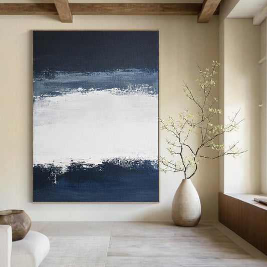 Large contemporary abstract painting featuring broad brush strokes in white and navy blue creating a tranquil atmosphere with a serene dark sky and soft gray clouds. DLZ0546