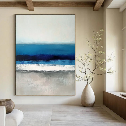 Large contemporary abstract painting featuring soft blues and grays capturing serene sea waves with a hint of deep blue for added depth. DLZ1359