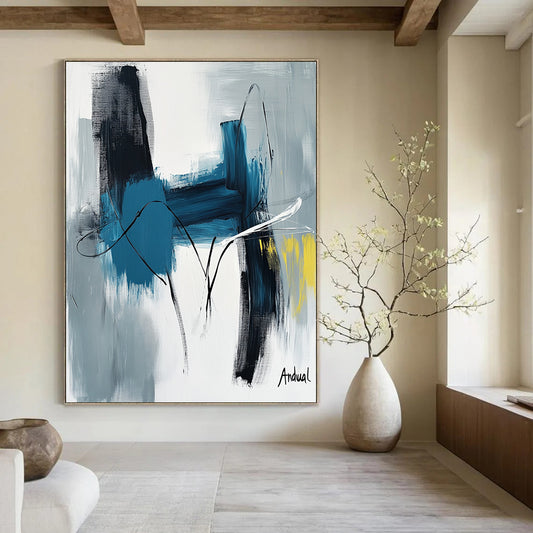 Contemporary abstract art showcasing "Andual" with bold strokes in blue and white on neutral canvas featuring black lines and hints of yellow or gray. DLZ0866