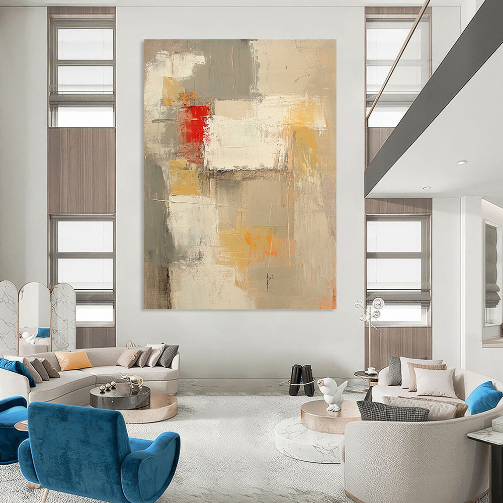 Contemporary abstract painting features neutral tones with red and yellow accents large brush strokes and textures in expansive white spaces. DLZ0921