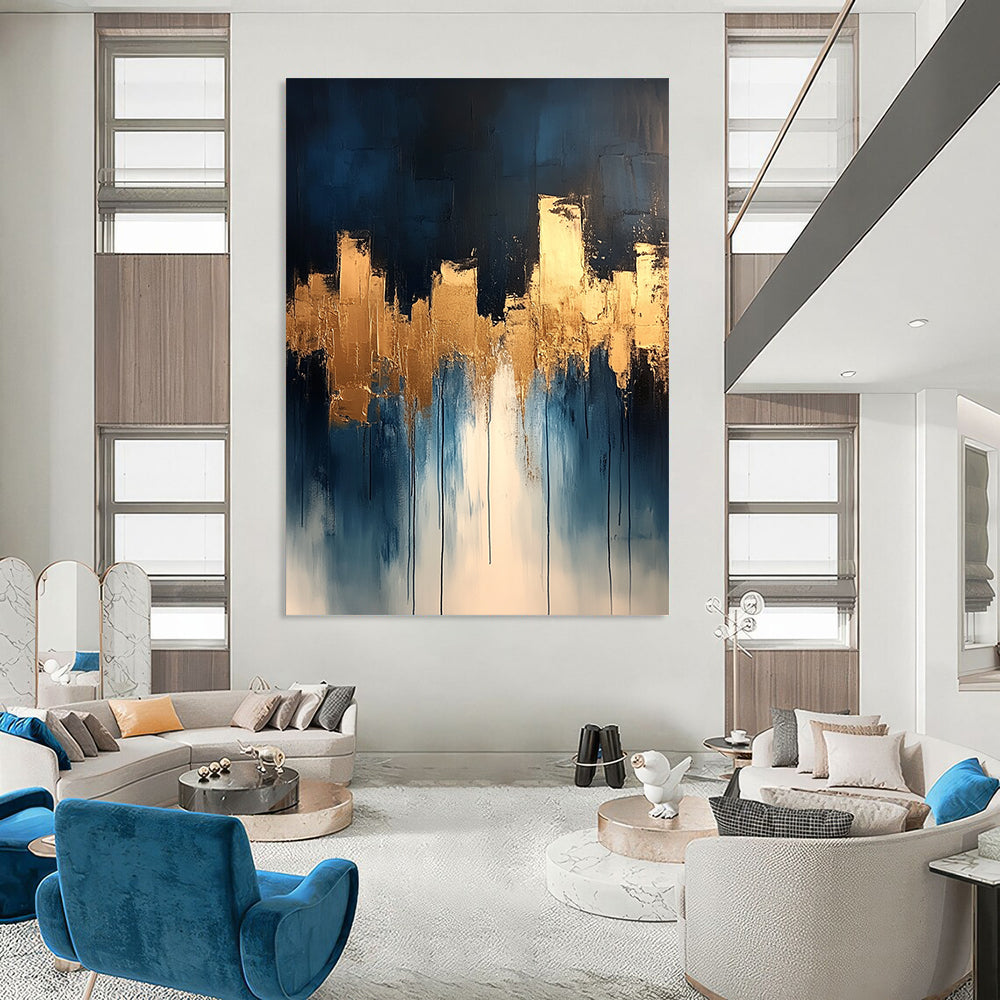 Contemporary abstract painting features dripping white and gold paint on canvas with vibrant blue tones and metallic gold leaf accents. DLZ0333