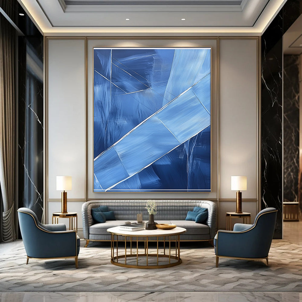 Contemporary hand-painted abstract art featuring blue shapes overlapping with soft edges and textured brushstrokes accented by a large white frame on the canvas. DLZ0367