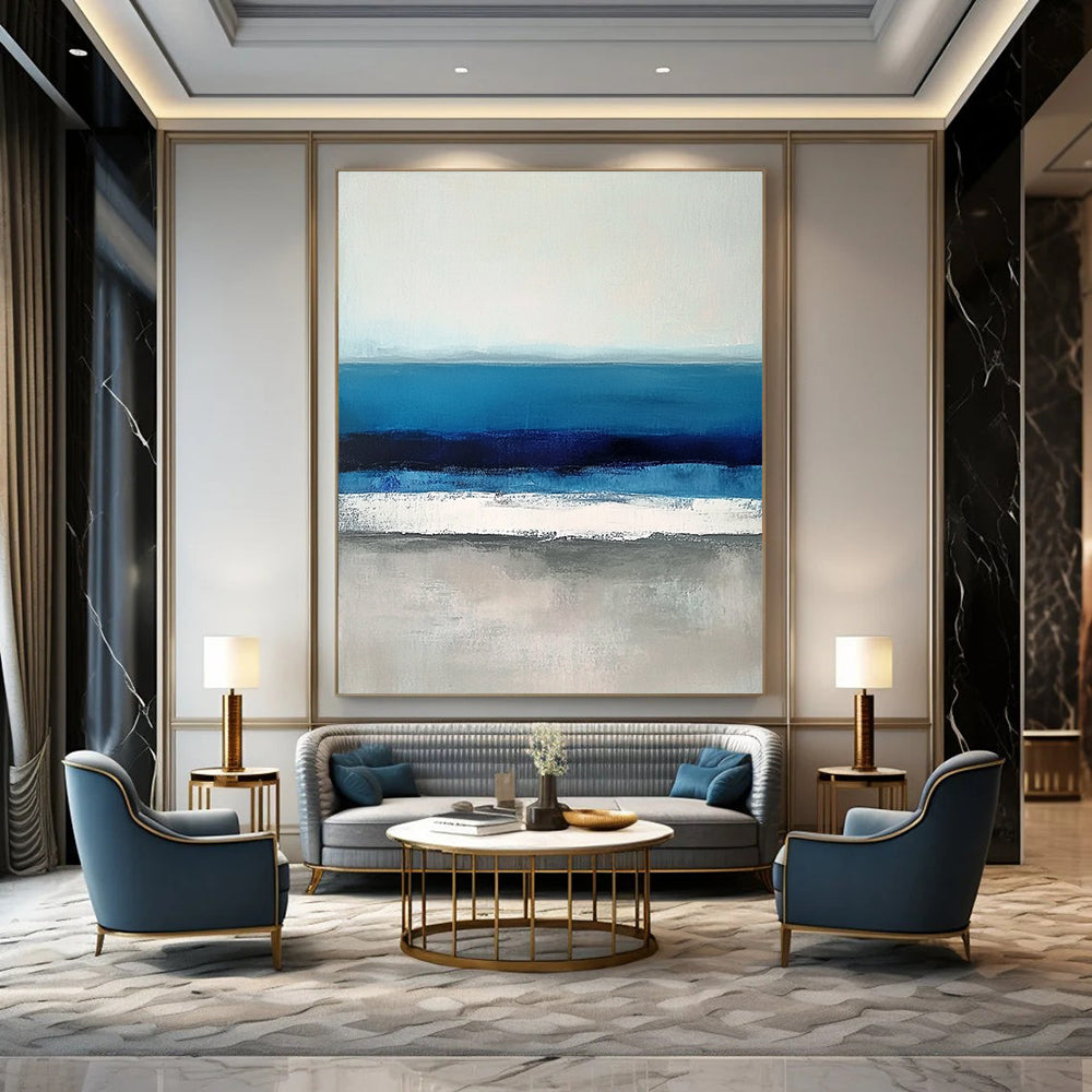 Large contemporary abstract painting featuring soft blues and grays capturing serene sea waves with a hint of deep blue for added depth. DLZ1359