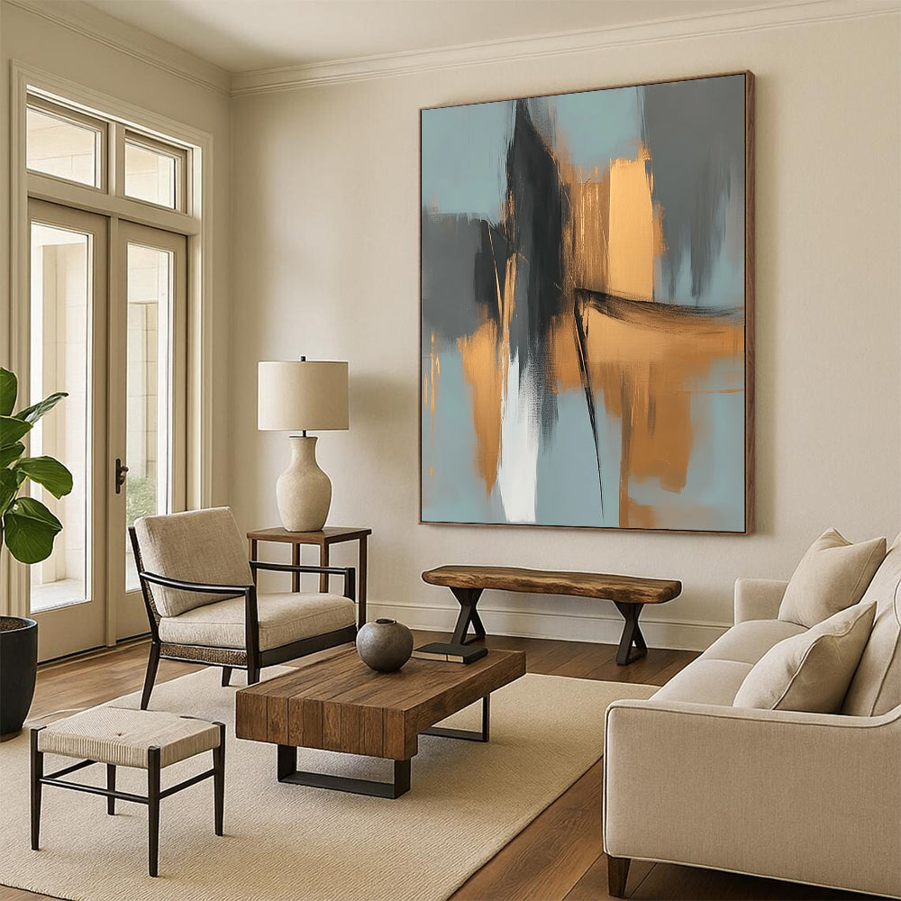Large contemporary abstract painting features elegant gold and gray shapes against a light blue background evoking an urban landscape with serene organic forms. DLZ0706
