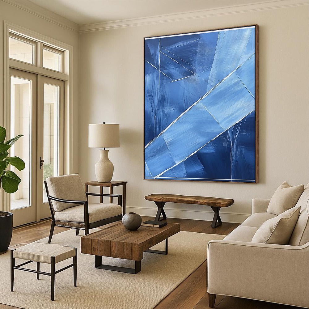 Contemporary hand-painted abstract art featuring blue shapes overlapping with soft edges and textured brushstrokes accented by a large white frame on the canvas. DLZ0367