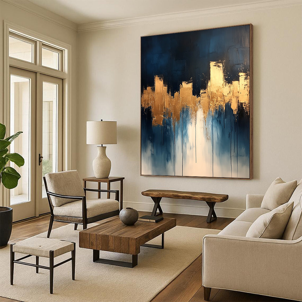 Contemporary abstract painting features dripping white and gold paint on canvas with vibrant blue tones and metallic gold leaf accents. DLZ0333