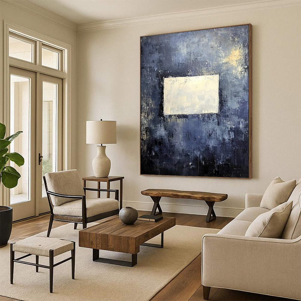 Bold contemporary abstract painting features a muted gray wall with dark blue and yellow tones highlighted by a central white square, creating a striking visual impact. DLZ0453