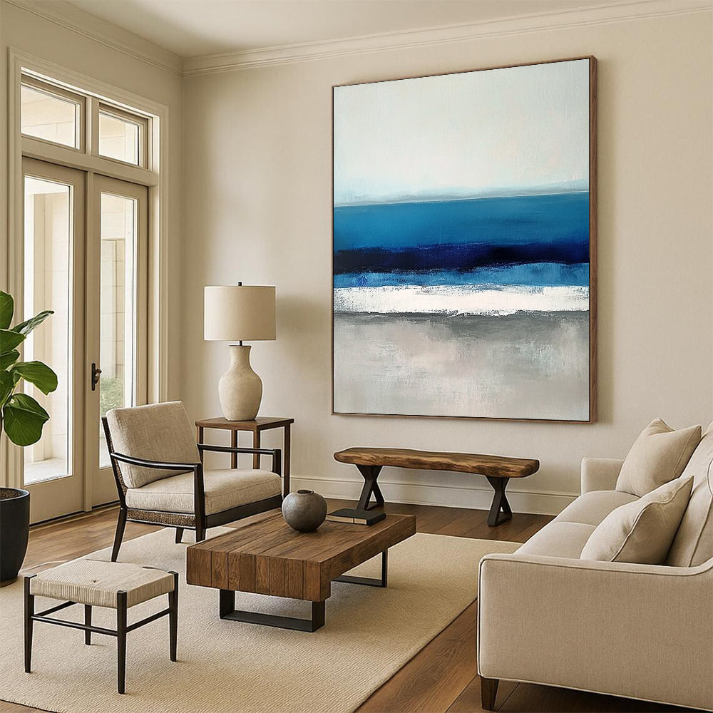 Large contemporary abstract painting featuring soft blues and grays capturing serene sea waves with a hint of deep blue for added depth. DLZ1359