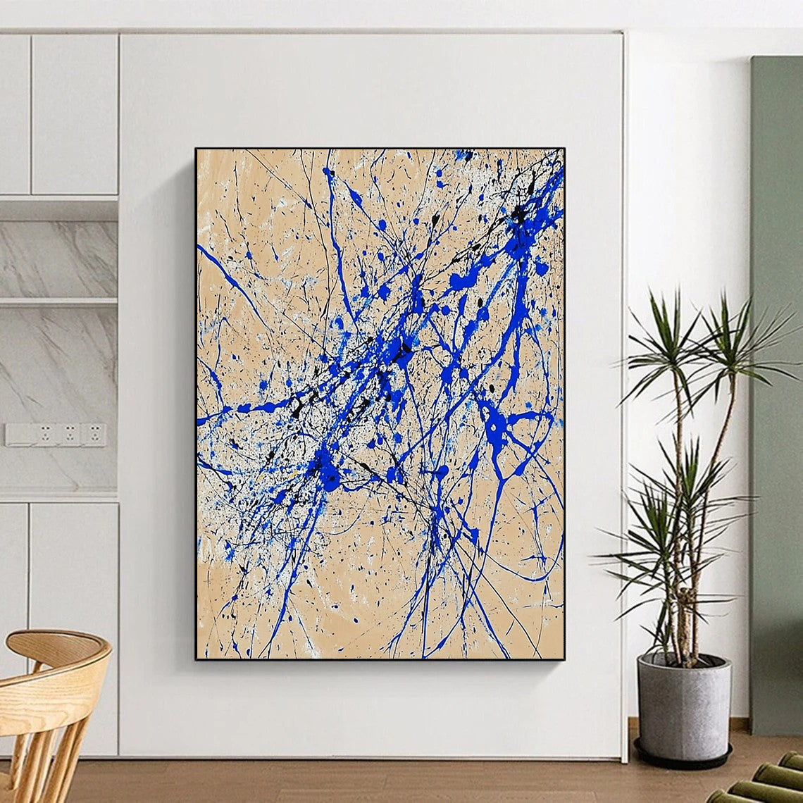 Contemporary abstract art features dynamic blue and white lines on beige paper in a vertical splatter style reminiscent of Jackson Pollock. DLZ0977
