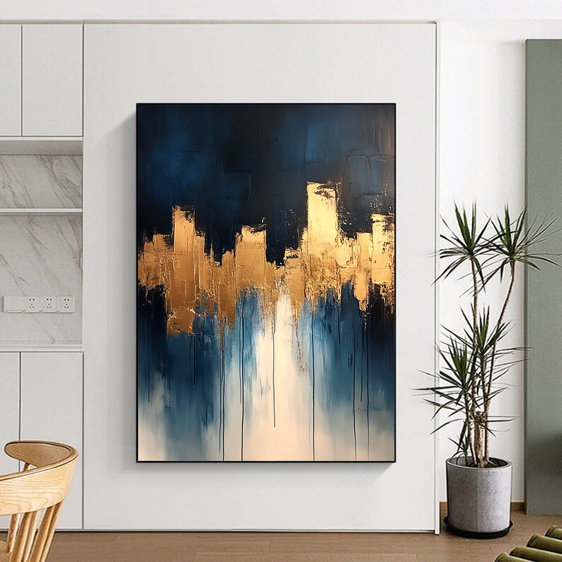 Contemporary abstract painting features dripping white and gold paint on canvas with vibrant blue tones and metallic gold leaf accents. DLZ0333