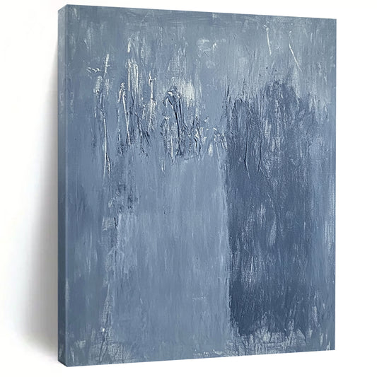 Large contemporary abstract painting in soft blue hues with textured surface and faint tree silhouettes against a deep gray background evoking calmness and emotion. DLZ1279