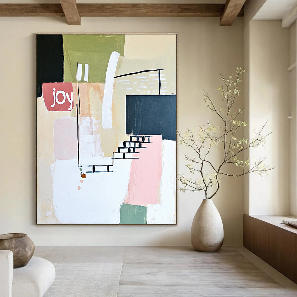 Contemporary abstract artwork features soft lines shapes and the word joy in white pale pink and green against a neutral background with a hint of staircase. DLZ1643