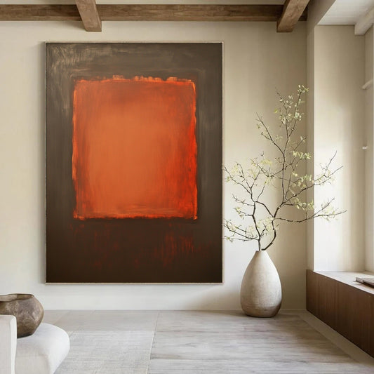Contemporary hand-painted abstract art features a large burnt sienna canvas with a small textured orange square against a dark gray background. DLZ1380