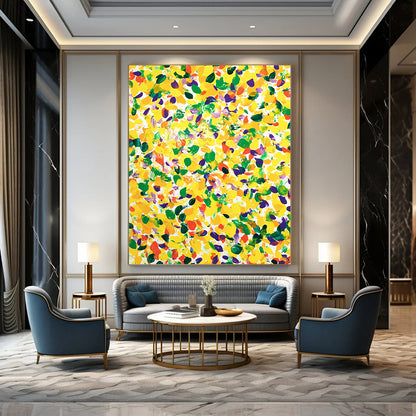 Vibrant contemporary abstract art featuring a large yellow canvas splashed with joyful green and purple spots against a clean white background. DLZ1297