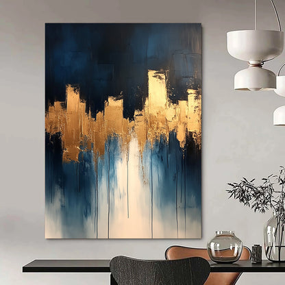 Contemporary abstract painting features dripping white and gold paint on canvas with vibrant blue tones and metallic gold leaf accents. DLZ0333