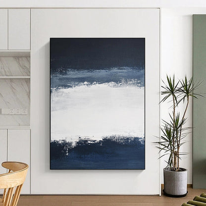 Large contemporary abstract painting featuring broad brush strokes in white and navy blue creating a tranquil atmosphere with a serene dark sky and soft gray clouds. DLZ0546