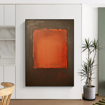 Contemporary hand-painted abstract art features a large burnt sienna canvas with a small textured orange square against a dark gray background. DLZ1380