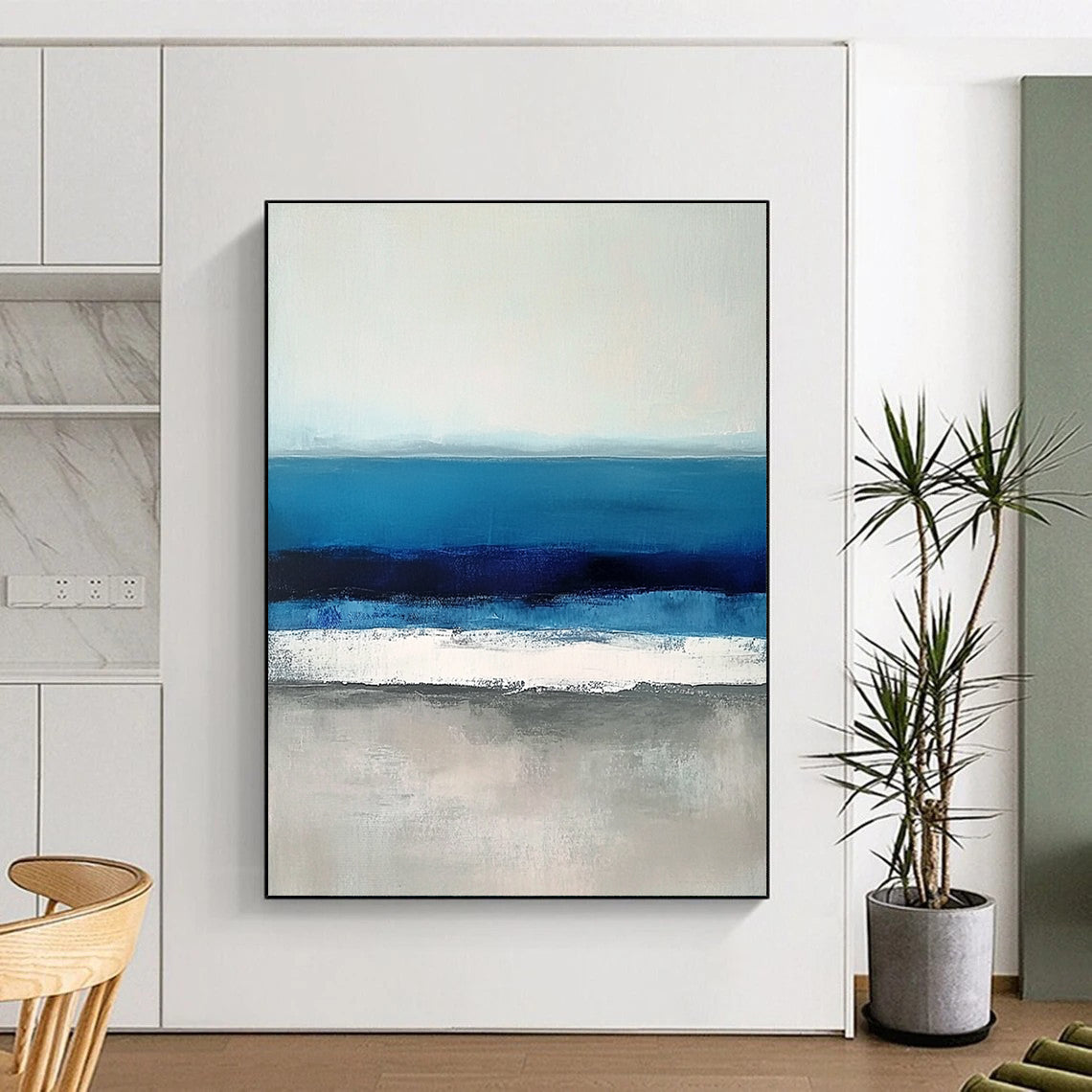 Large contemporary abstract painting featuring soft blues and grays capturing serene sea waves with a hint of deep blue for added depth. DLZ1359